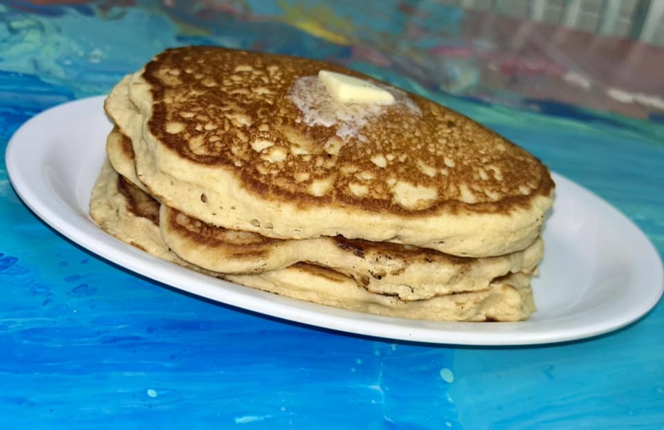 A stack of buttery golden-brown pancakes on a pate.