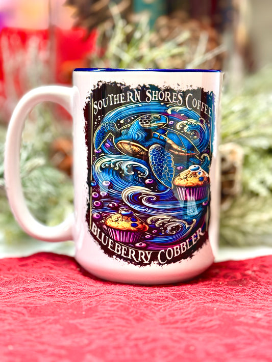 A coffee mug with a sea turtle and waves of blueberry muffins surrounded by the words southern shores coffee. 