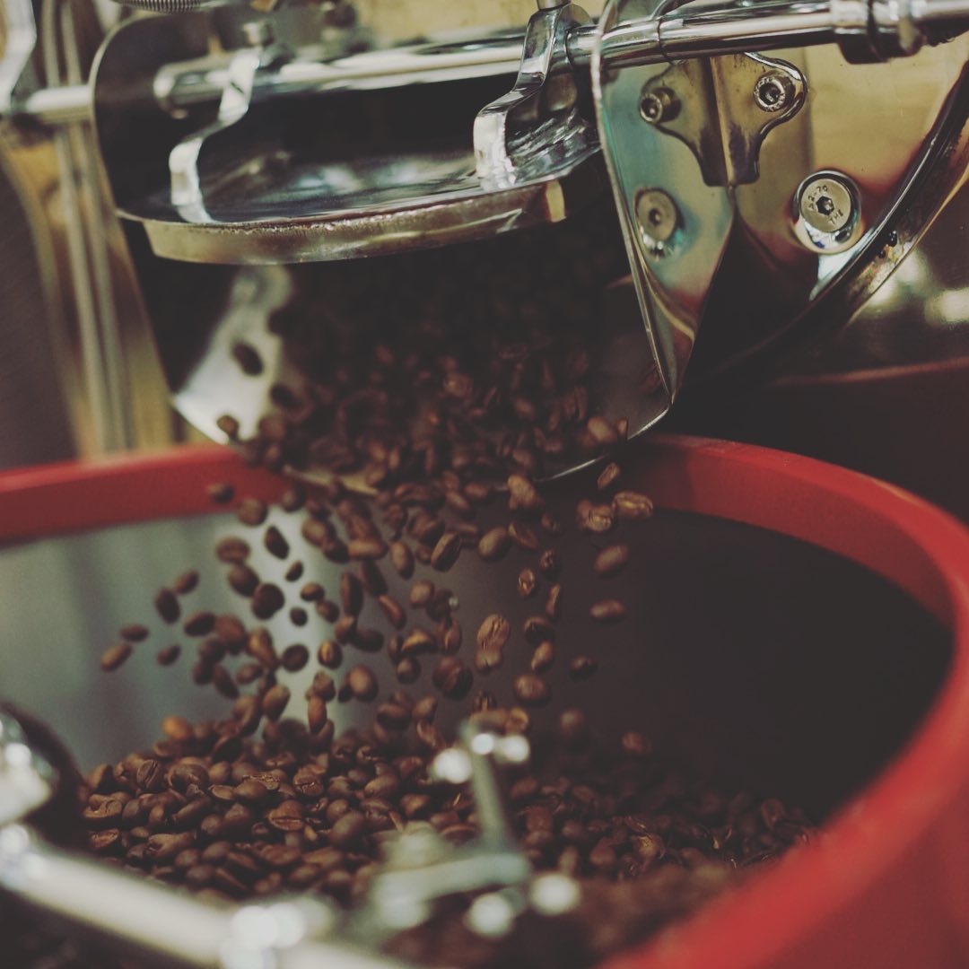 Coffee beans exiting a coffee roaster to be cooled off.