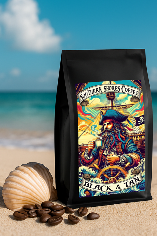 Black and Tan coffee bag on the beach with a seashell and coffee beans scattered.