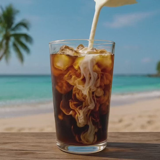 video of an Iced Bushwacker coffee with cream being added with a beach background 